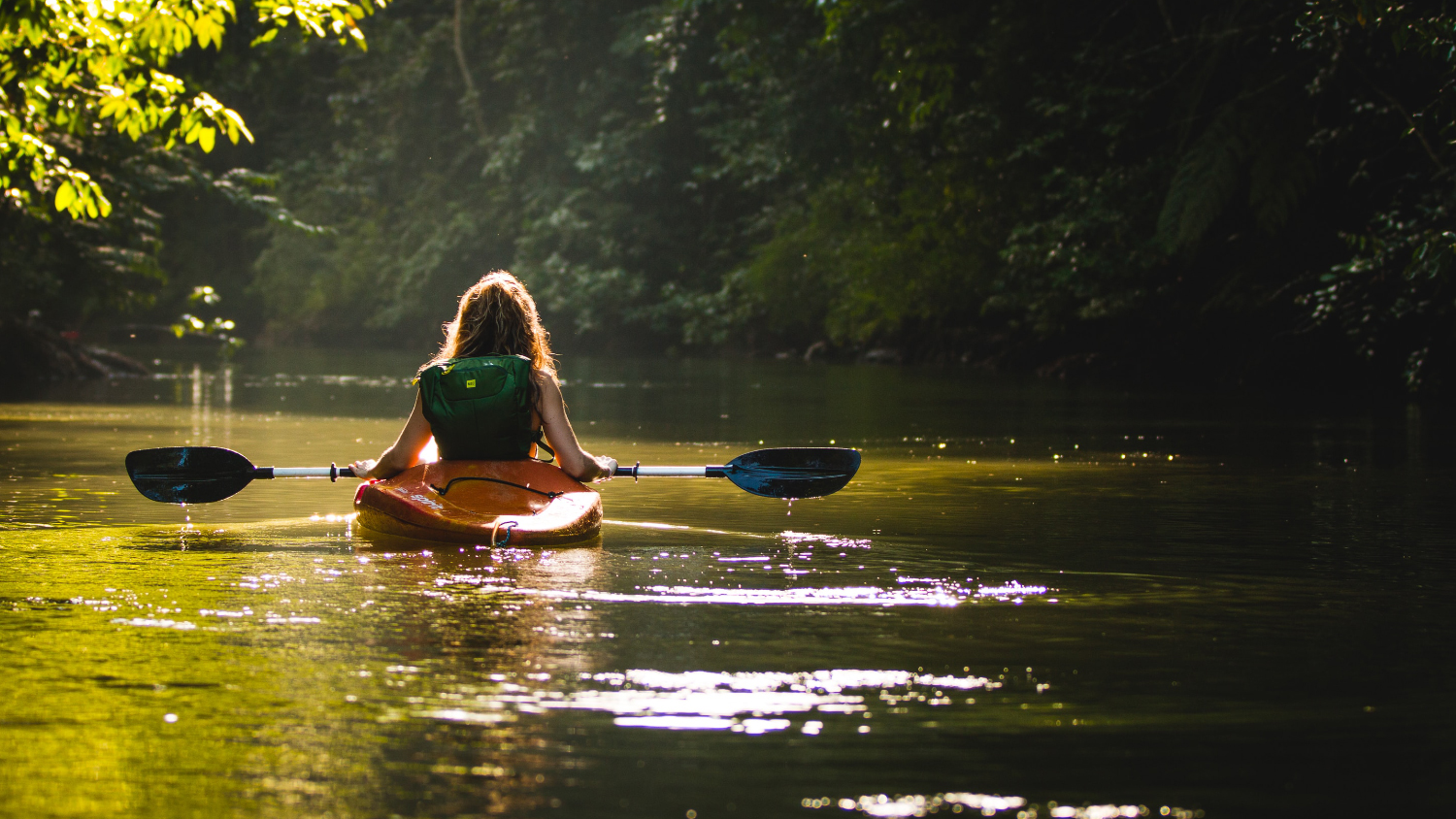 A woman kayaks on a lake